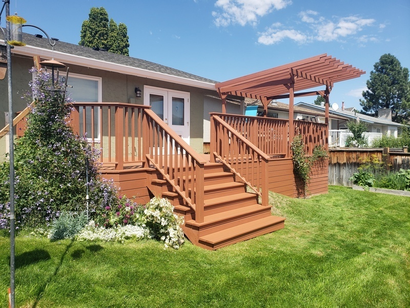 Custom-built backyard deck with stairs and pergola structure